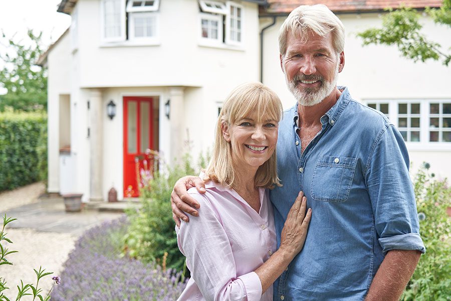 Personal Insurance - Mature Couple Standing Outside Their Country Home